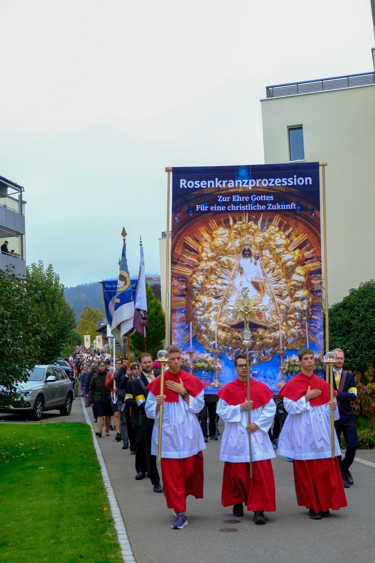 Prozession (12 von 33)-web-min Rosenkranzprozessionsteilnehmer ziehen durch die Straßen von Einsiedeln mit großer Marienfahne