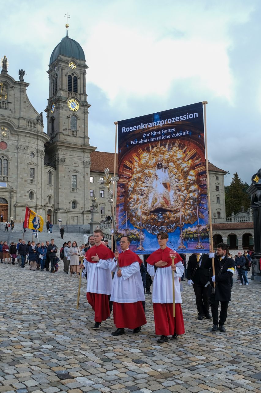 Einsiedeln_2026 (42 von 47)-1280 Rosenkranzprozessionsteilnehmer ziehen durch die Straßen von Einsiedeln mit großer Marienfahne